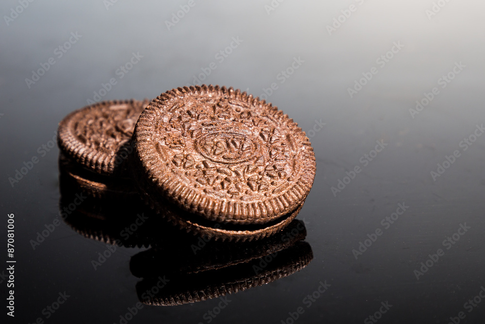 Creme-filled sandwich cookies on dark reflective background Creme-filled sandwich cookies on dark reflective background