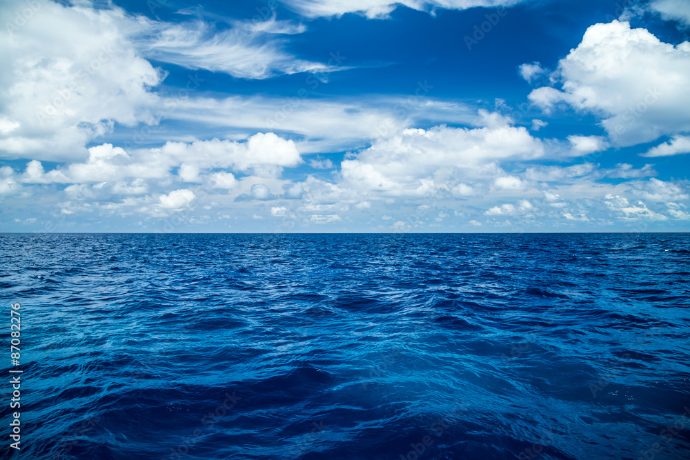 Obraz premium tło błękitnego oceanu z niebieskim pochmurne niebo