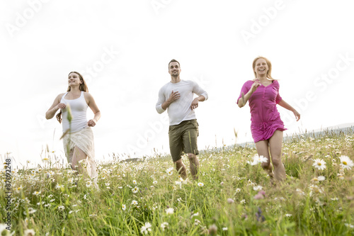 happy friends spending free time together in a field