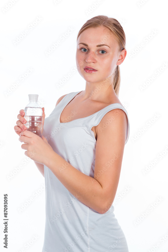 Portrait of a young happy girl holding a bottle of water after fitness and smiles, isolated on a white background Portrait of a young happy girl holding a bottle of water after fitness and smiles, isolated on a white background