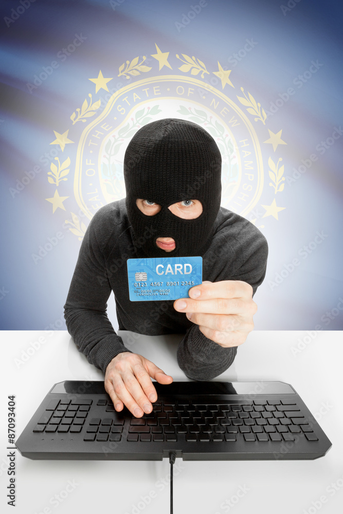 Hacker holding credit card with US state flag on background - New Hampshire Hacker holding credit card with US state flag on background - New Hampshire