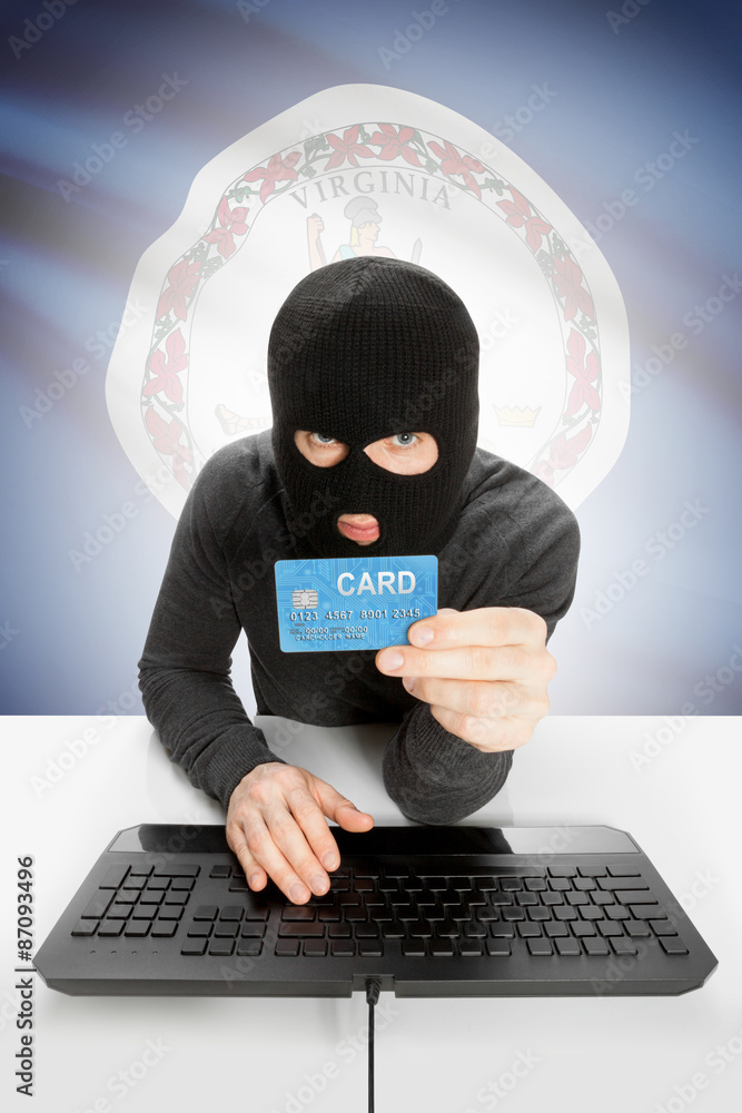 Hacker holding credit card with US state flag on background - Virginia Hacker holding credit card with US state flag on background - Virginia