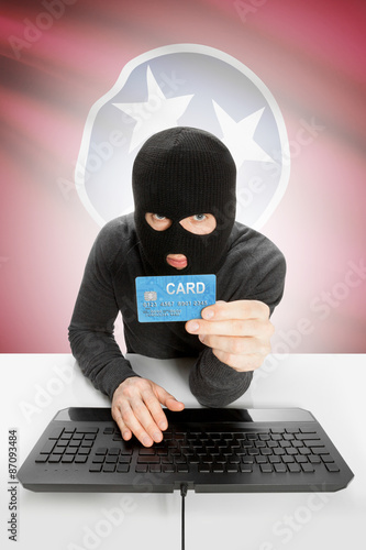 Hacker holding credit card with US state flag on background - Tennessee