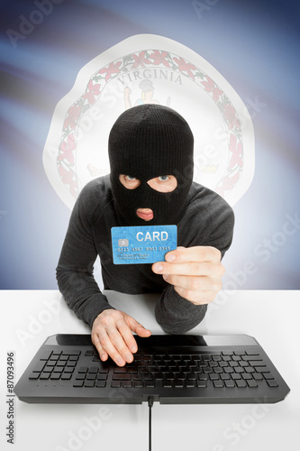 Hacker holding credit card with US state flag on background - Virginia