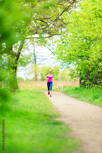Woman runner running jogging in summer park