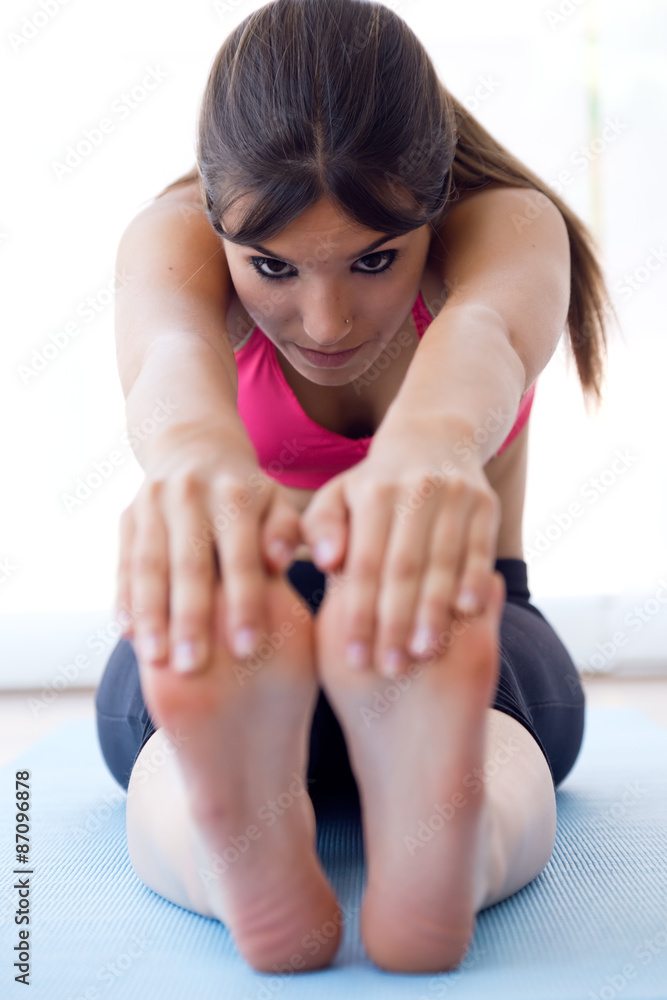 Fototapeta premium Beautiful healthy young woman doing exercise at home.