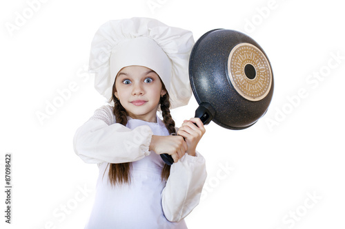 Smiling little girl in cook hat with frying pan