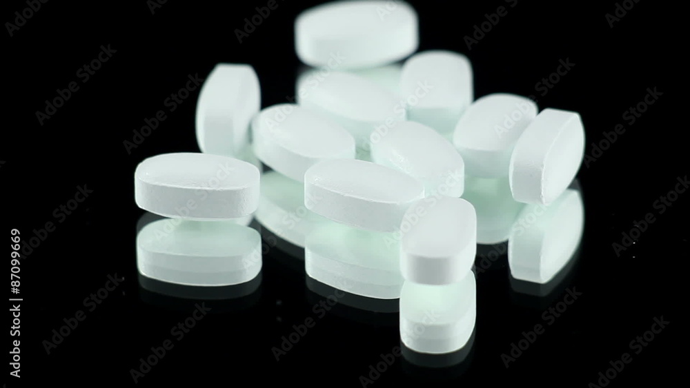 White Pills on a Rotating Black Background. Pharmacology White Pills on a Rotating Black Background. Pharmacology