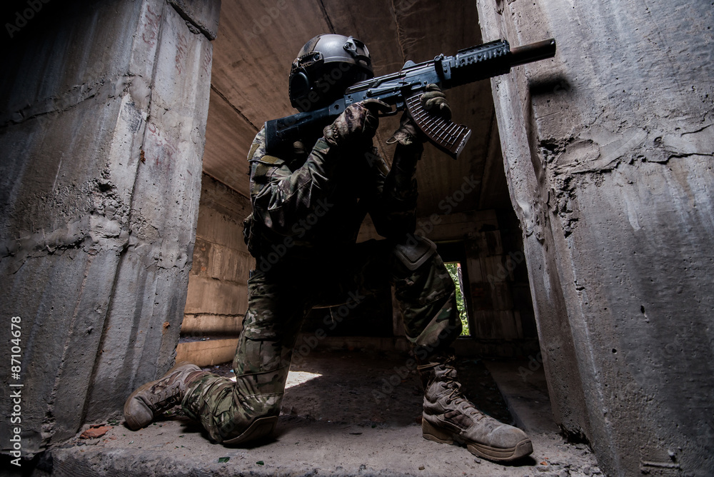 Fototapeta premium Special forces soldier aiming a rifle in dark room