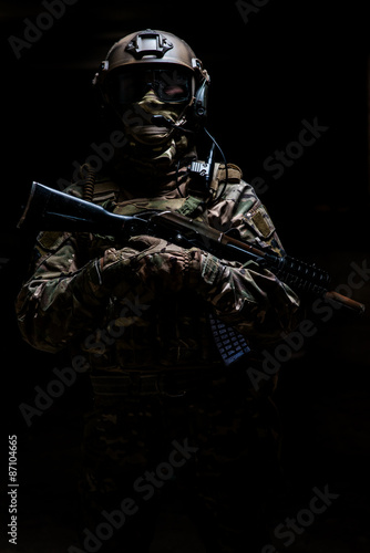 Armed ranger in camouflage standing and looking at the camera