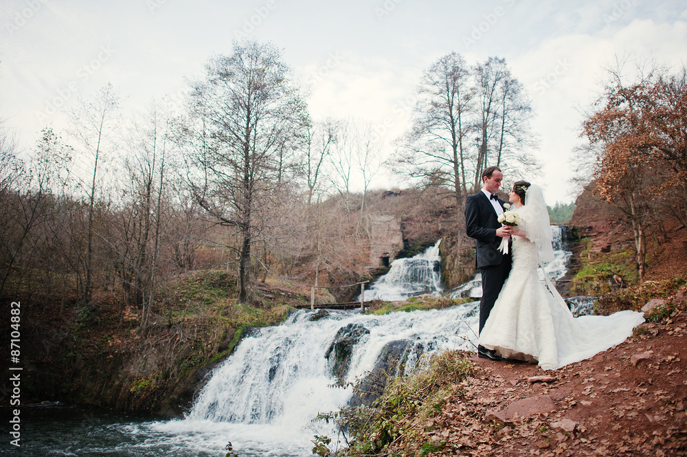 lovely newlyweds background waterfall at cold autumn day lovely newlyweds background waterfall at cold autumn day
