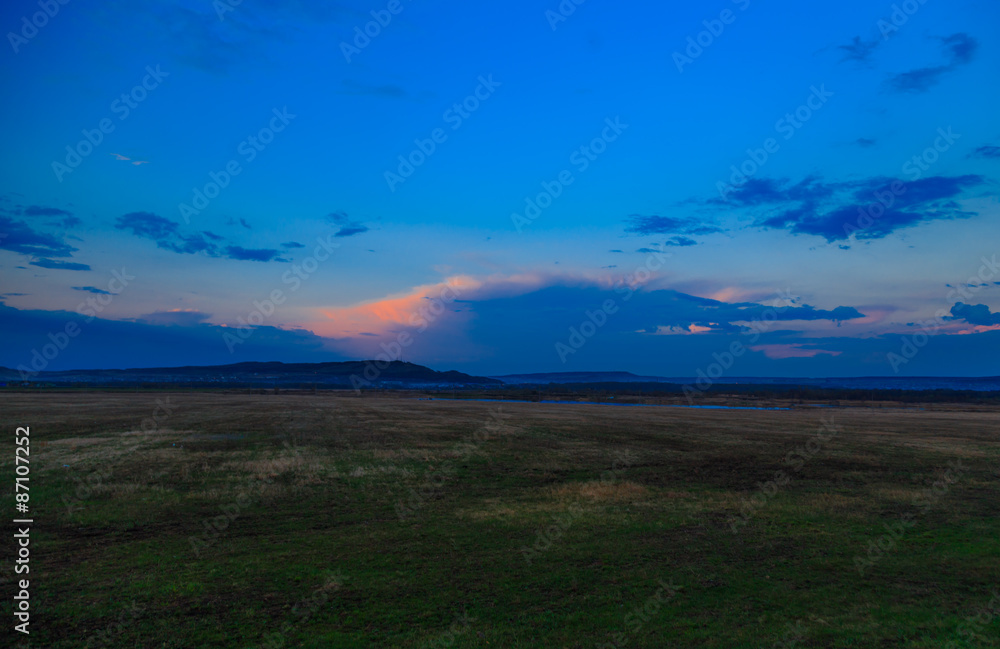 Fototapeta premium sunset blue sky over hills and field