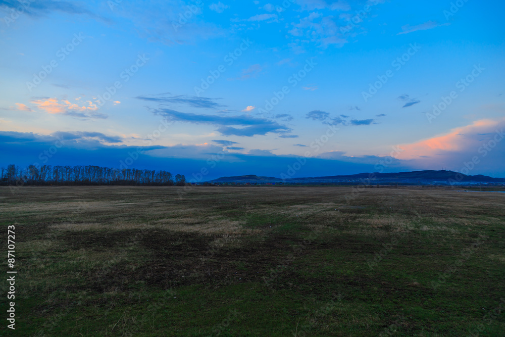 sunset blue sky over hills and field sunset blue sky over hills and field