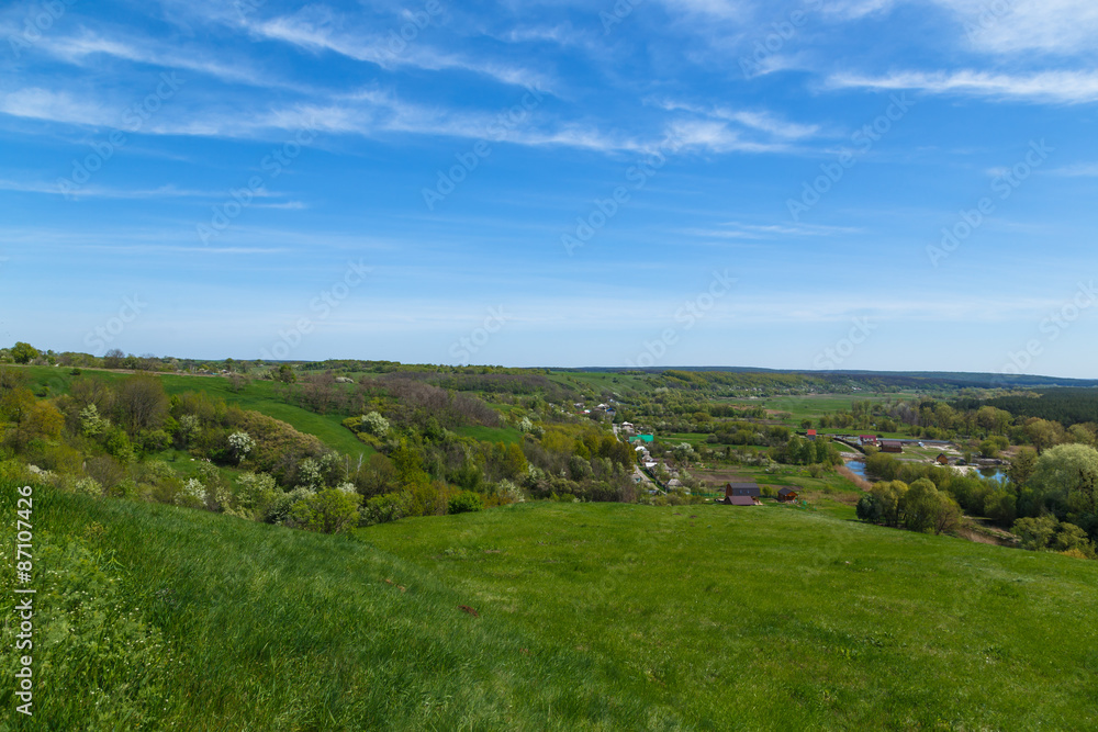 view from hill to village in canyon with sky clouds