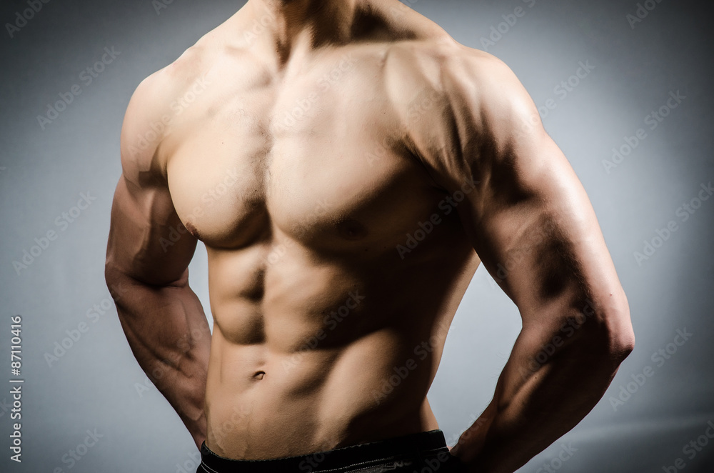 Muscular man posing in dark studio Muscular man posing in dark studio