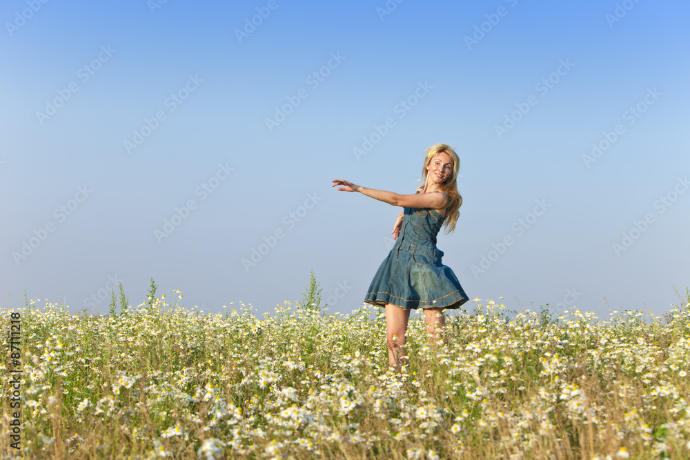 The happy young woman in the field of camomiles The happy young woman in the field of camomiles