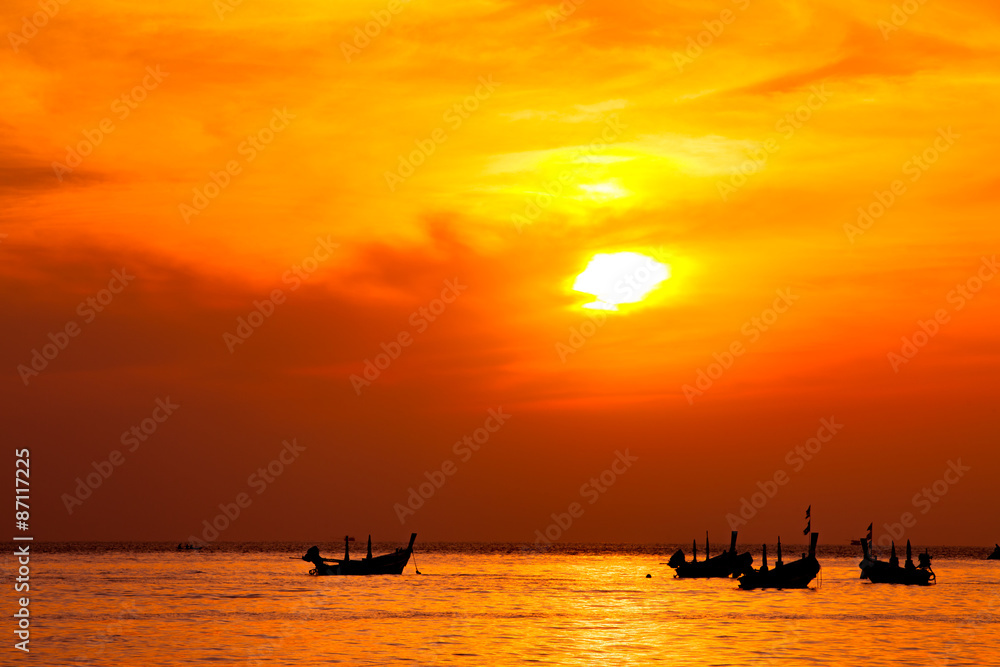 silhouette of fishermen boats fishing in sunset at the beach.