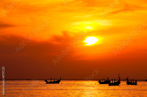 silhouette of fishermen boats fishing in sunset at the beach.