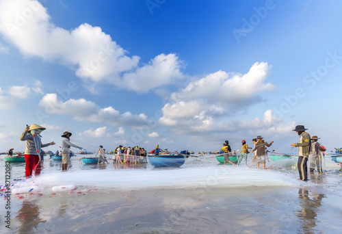 Binh Thuan Sea, Vietnamese - March 22, 2015: a group of fishermen netting fish carving on a summer morning in the waters of Ke Ga, Binh Thuan, the Vietnamese photo