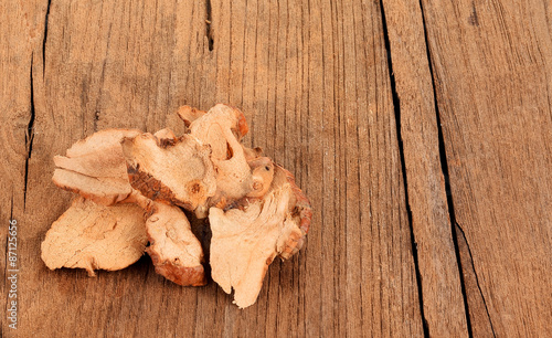 Dried galangal on wooden background