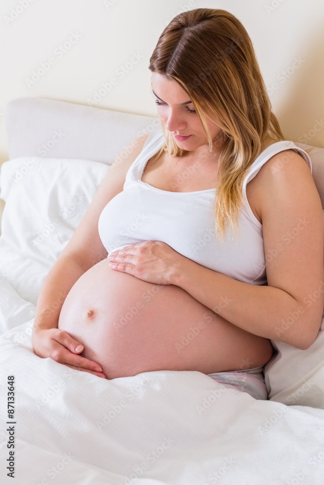 Pregnant woman looking at her belly Pregnant woman looking at her belly
