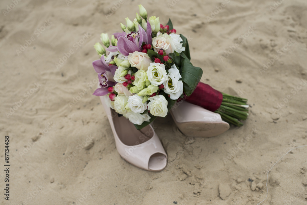 wedding bouquet and shoes in the sand wedding bouquet and shoes in the sand