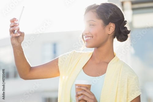  Smiling beautiful brunette taking selfie