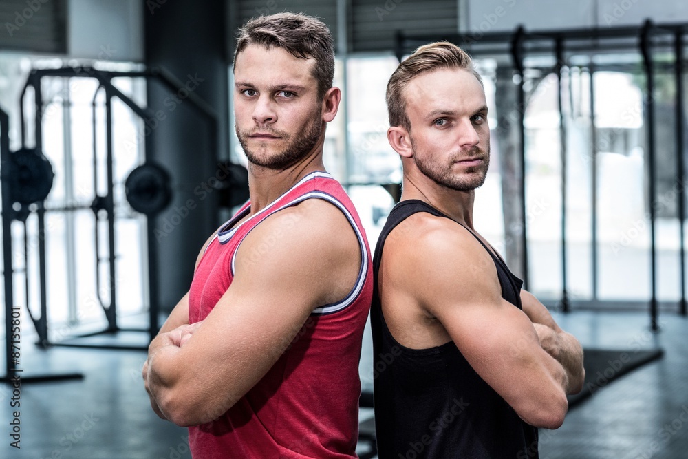 Two muscular men giving back to back Two muscular men giving back to back