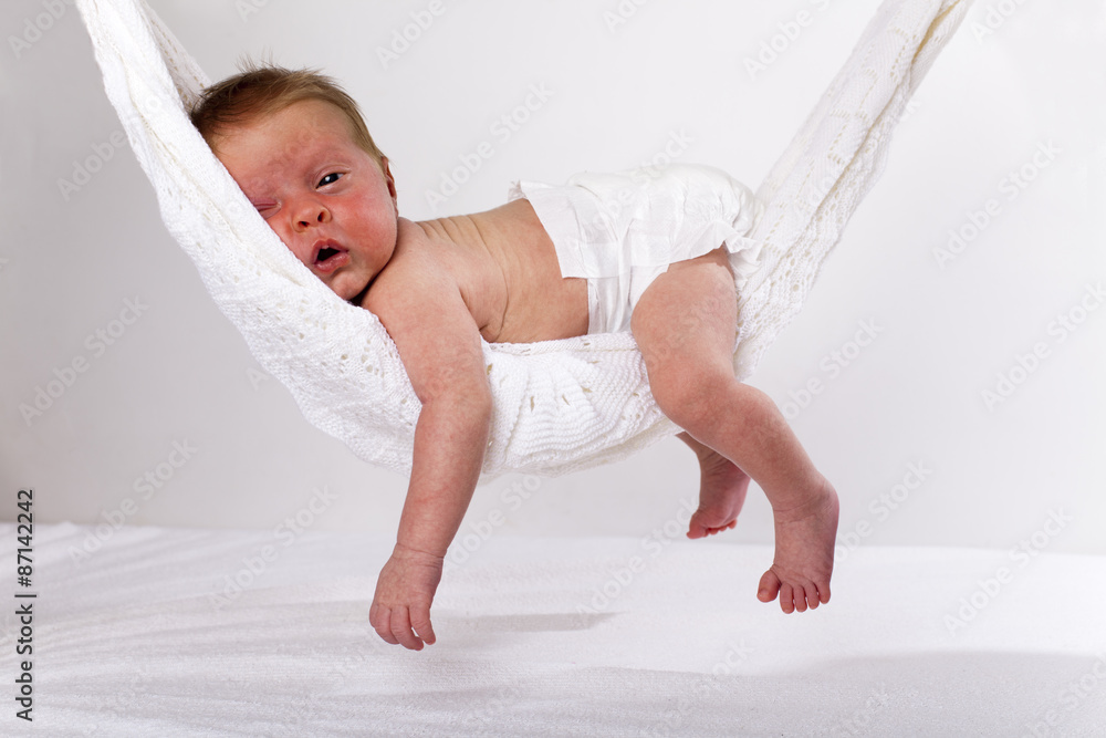 Adorable bebé tumbado boca abajo sobre una colorida colchoneta para niños  con su puño en la boca. Retrato de un bebé alegre jugando en el suelo. Bebés  felices que tienen f Fotografía