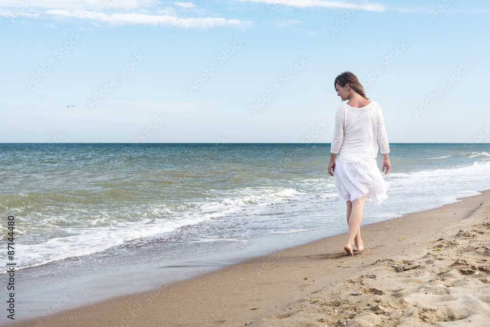 Woman in summer dress standing on a sea Woman in summer dress standing on a sea
