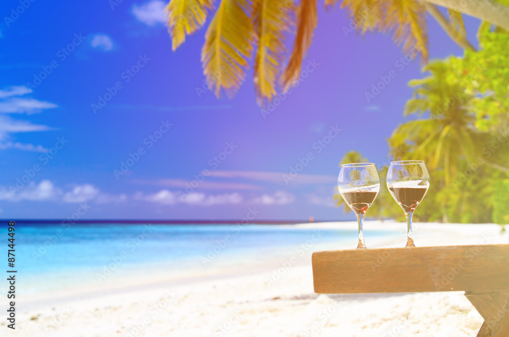 two wine glasses on sand beach