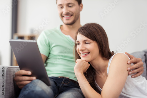 Sweet Happy Couple Watching Something on Tablet
