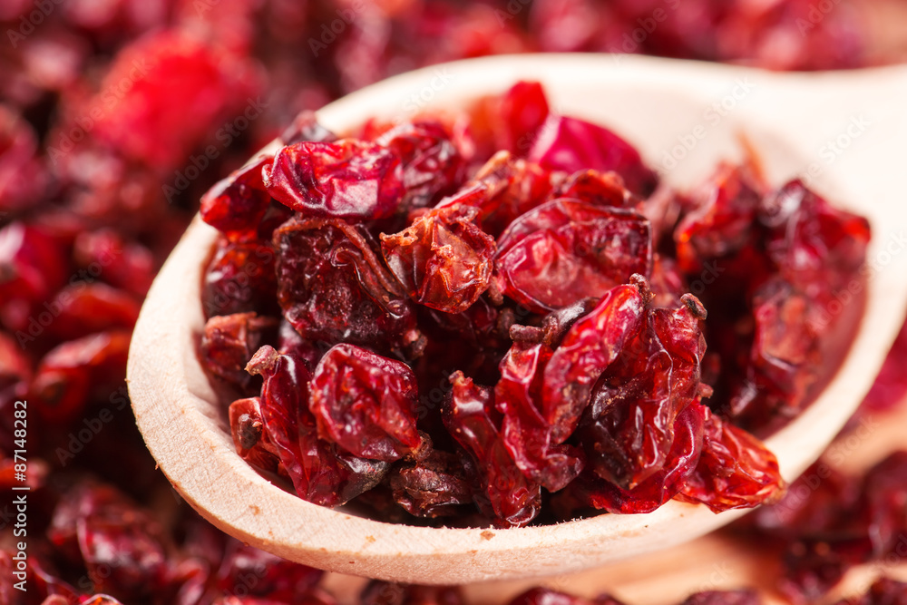Dry red barberry spices in the wooden spoons Dry red barberry spices in the wooden spoons