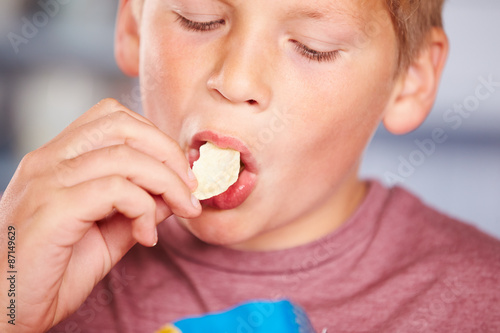 Close Up Of Boy Eating Packet Of Potato Chips