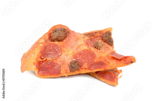 two slices leftover pizza on white background