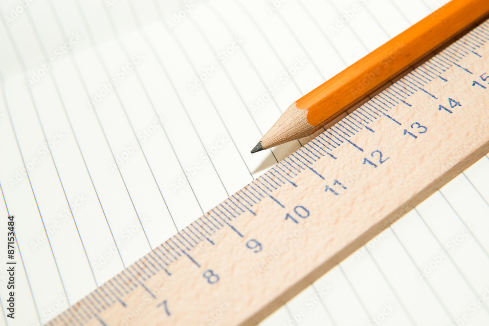 Notepads, pencil and wooden ruler on the old tissue Notepads, pencil and wooden ruler on the old tissue