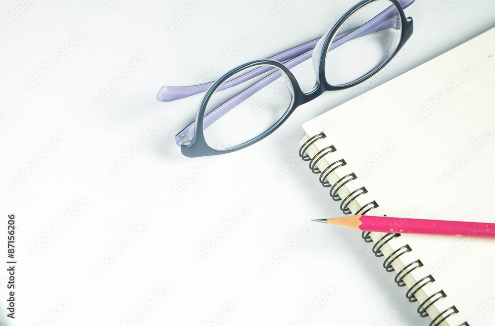 view from above on white office table with notepad, pencil and eyeglasses view from above on white office table with notepad, pencil and eyeglasses
