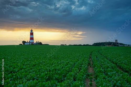 Happisburgh Lighthouse in Norfolk at sunset during as passing storm.