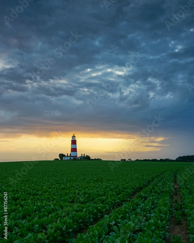 Happisburgh Lighthouse in Norfolk at sunset during as passing storm.