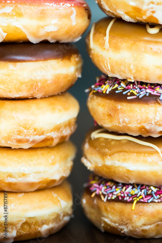 Stacks of Glazed Doughnuts with colourful sprinkles, chocolate,