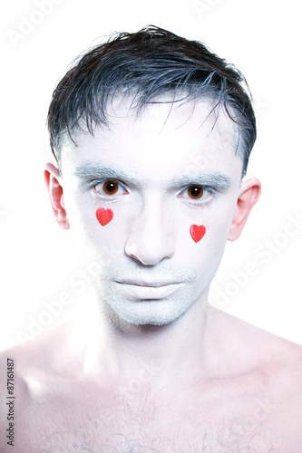 man with white makeup and red hearts instead of tears