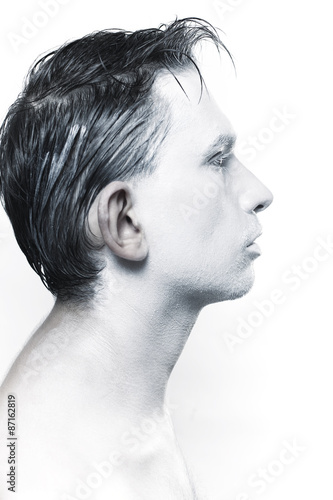 Profile of beautiful young guy with white makeup photo