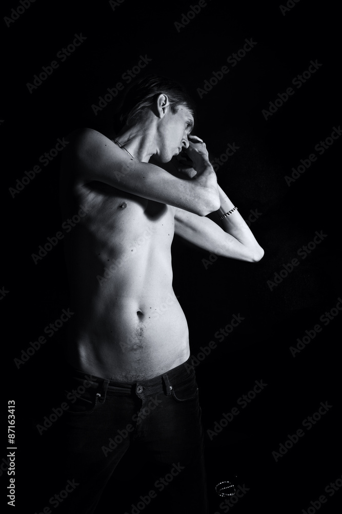 young slender naked man on a black background young slender naked man on a black background