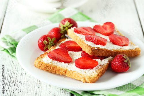 Fresh toast with strawberry on white wooden background