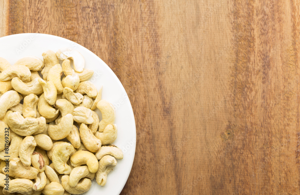 Cashew nuts on a rustic wooden against wood background Cashew nuts on a rustic wooden against wood background