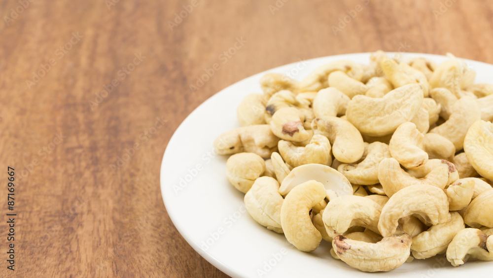 Cashew nuts on a rustic wooden against wood background Cashew nuts on a rustic wooden against wood background