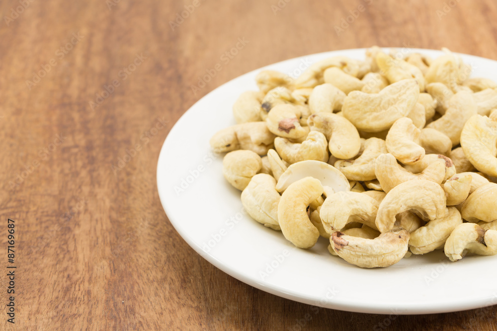 Cashew nuts on a rustic wooden against wood background Cashew nuts on a rustic wooden against wood background