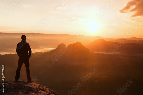 Tableau sur toile Hiker stand on the sharp corner of sandstone rock in rock empires park and watching over the misty and foggy morning valley to Sun