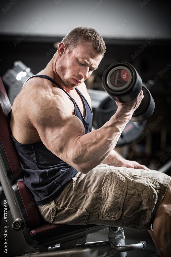 Man at fitness training with dumbbells in gym Man at fitness training with dumbbells in gym