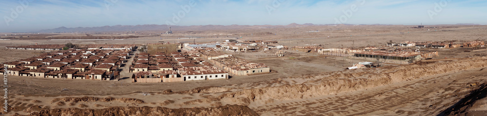 Derelict accommodation and office buildings at the historic Humberstone Saltpeter Works in the Atacama Desert near Iquique in Chile. The site is now a museum and a Unesco World Heritage SIte.